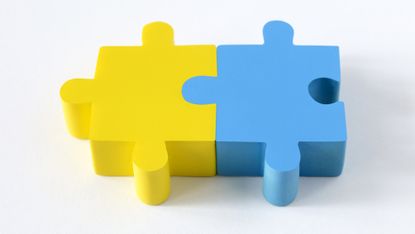 Two connected puzzle pieces, one yellow and one blue.