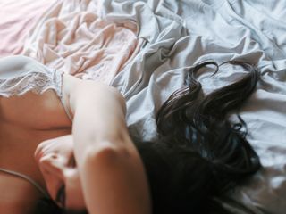 Sex dream meaning: A woman lies in bed while having a sex dream