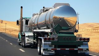 A rear view of a tanker truck on a highway.
