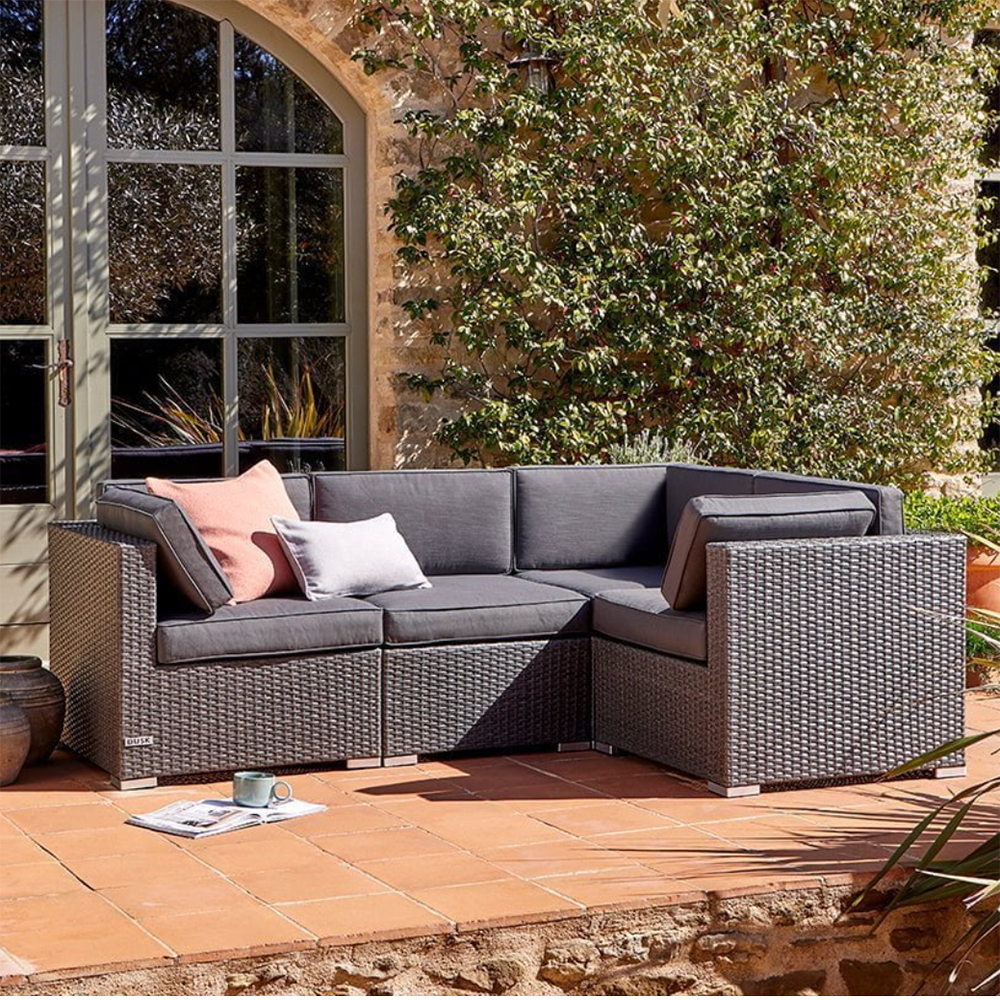 rattan corner sofa in a garden showing the house exterior in the background