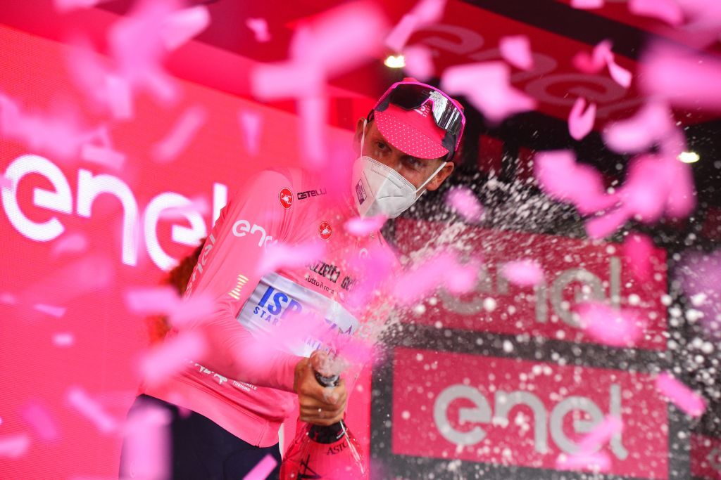 Team Israel StartUp Nation rider Italys Alessandro De Marchi sprays champagne as he celebrates his overall leaders pink jersey on the podium of the fifth stage of the Giro dItalia 2021 cycling race 177 km between Modena and Cattolica EmiliaRomagna on May 12 2021 Photo by Dario BELINGHERI AFP Photo by DARIO BELINGHERIAFP via Getty Images