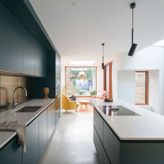 modern green kitchen with kitchen island and a seating area beside a window