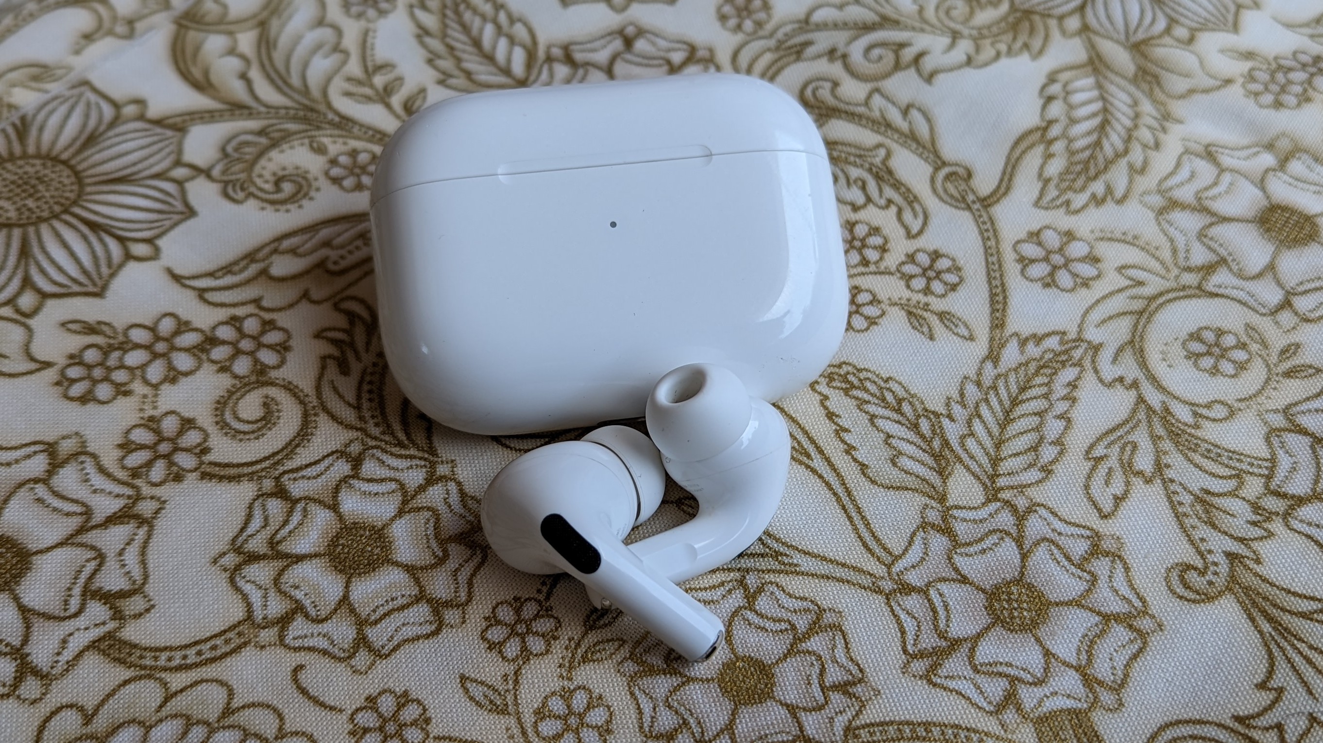 The AirPods Pro displayed on a white and gold cloth