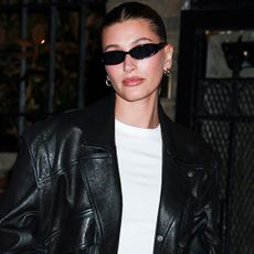 Hailey Bieber wore low-rise, dark-wash jeans with the heeled flip-fllops and baseball tee trends