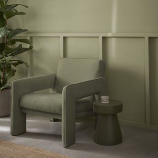 a muted green room with a matching chair