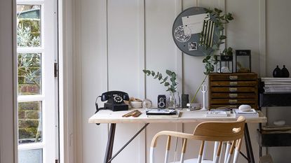 modern home office ideas, home office with modern wallpaper behind desk and shelving, blue velvet chair 