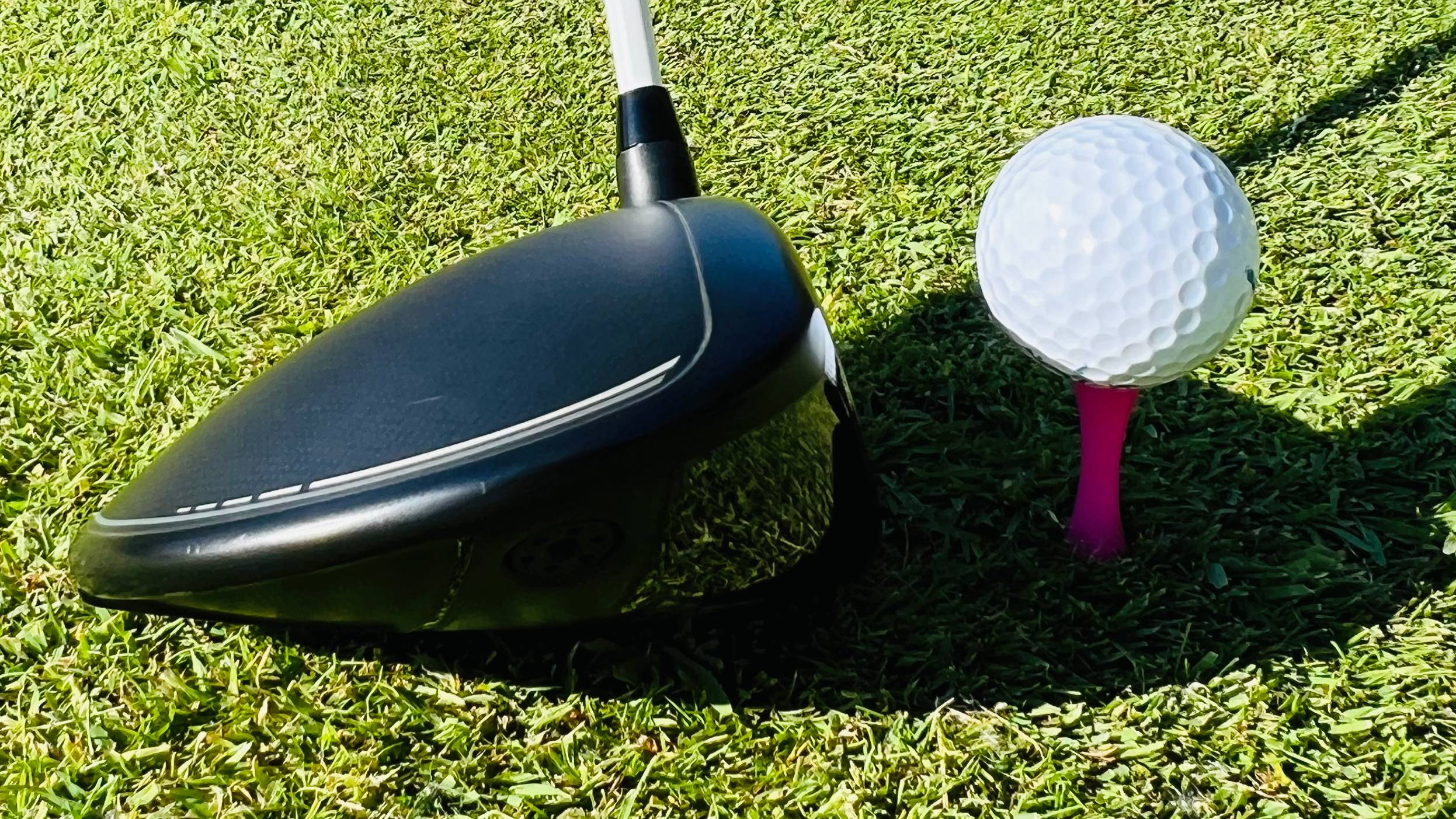 Driver addressing ball on pink &#039;castle&#039; tee