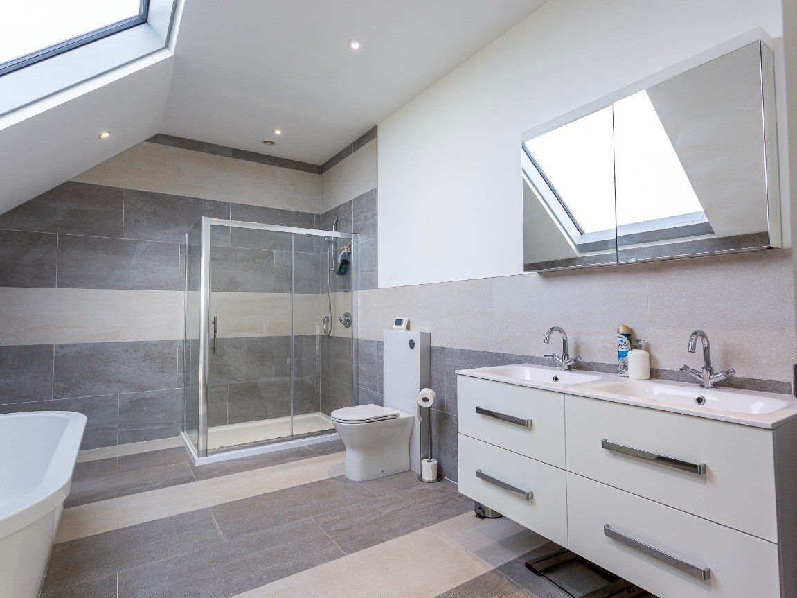 The bathroom with large bath and tiled walls