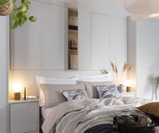 bedroom with slimline cupboards in pale grey colour built in above bed