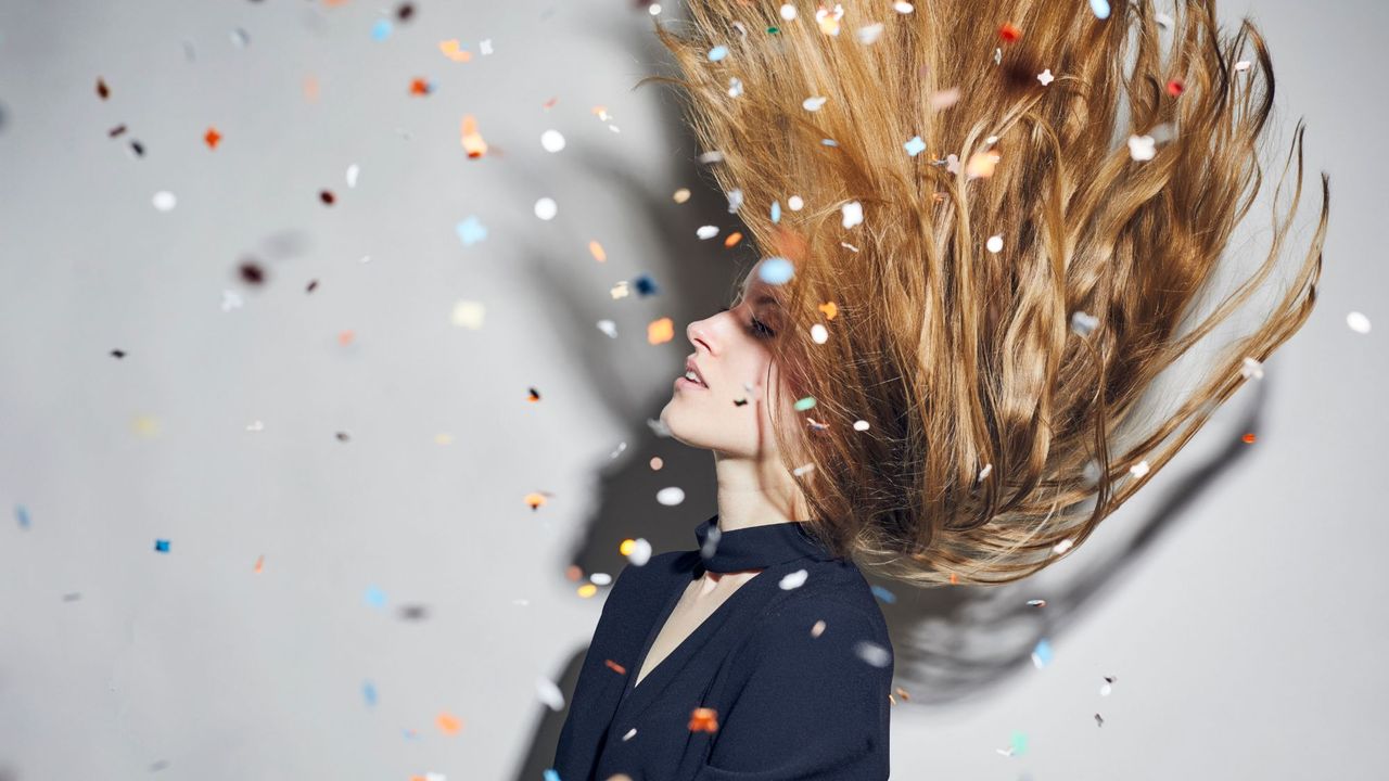 L&#039;Oréal Steampod - woman tossing hair under shower of confetti - gettyimages 900251340