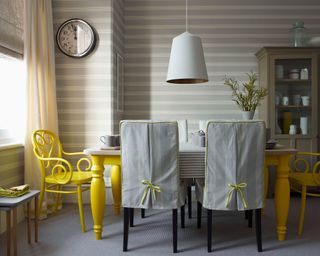 How to style a display cabinet - dining room with large dining table oversized lighting and yellow colour pops with a glass fronted dresser