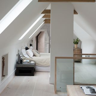 attic bedroom with wooden bed mattress and pillows with wooden flooring