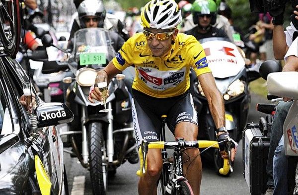 Sastre enjoys a glass of champagne with Bjarne Riis in the CSC team car.