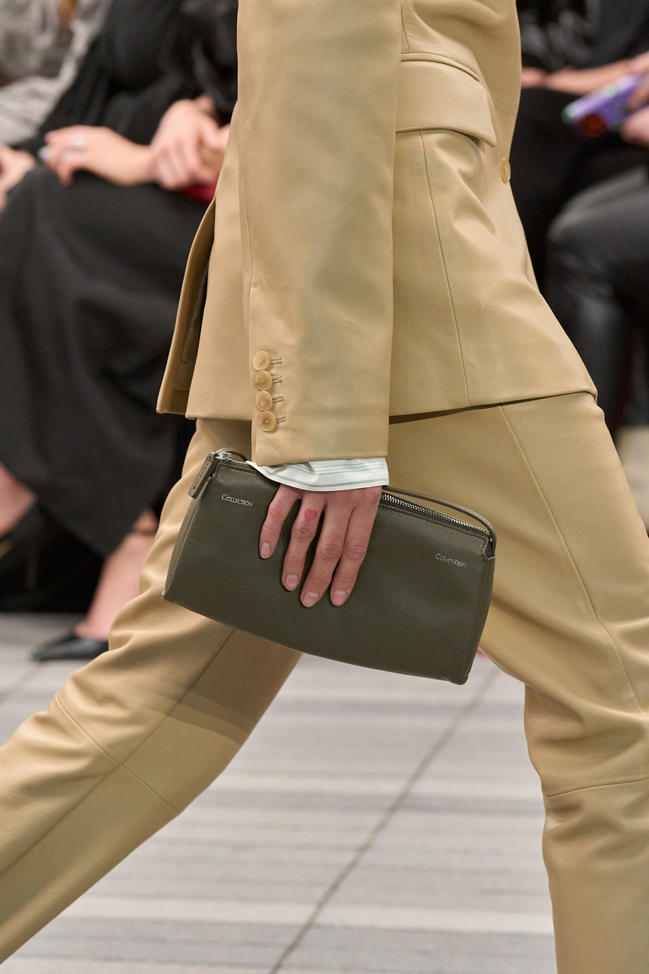 Calvin Klein Fall 2026 runway, model carrying a green clutch
