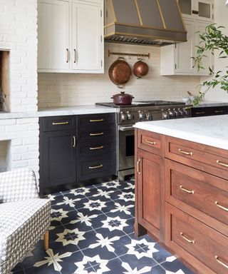 A wooden kitchen with vintage hardware and a patterned floor tile design