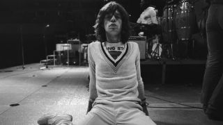 Mick Jagger sitting on a stage