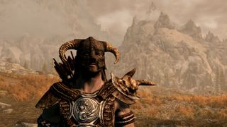 A Nord in a horned helmet stands in front of some mountains