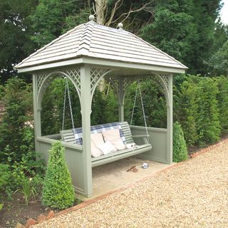 swing seat in a garden surrounded by greenery