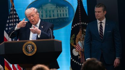WASHINGTON, D.C. - APRIL 7: U.S. President Donald Trump mimics firing a rifle while speaking to reporters at a briefing on Monday, April 6, 2026 at the White House in Washington, D.C. Trump discussed the rescue of an American pilot and the ongoing war with Iran. Defense Secretary Pete Hegseth and Army Secretary Gen. Dan Caine joined Trump. (Photo by Maxine Wallace/The Washington Post via Getty Images)