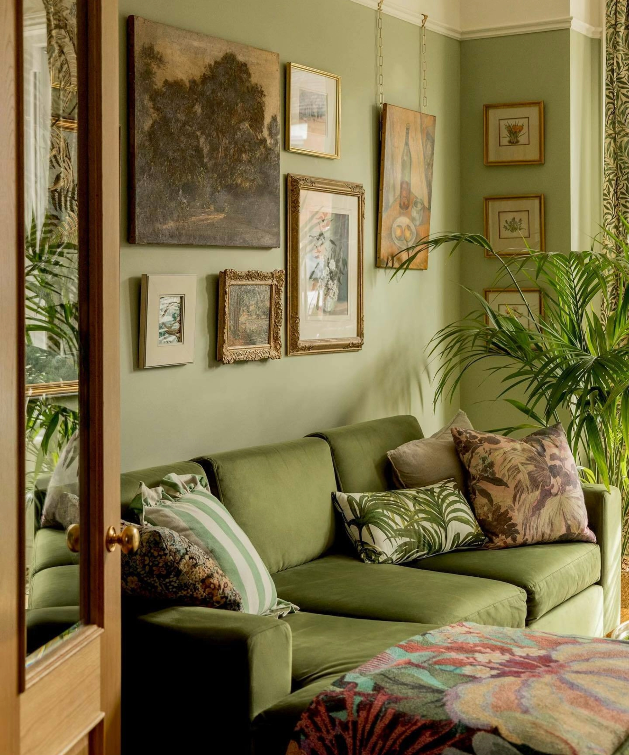 Green living room with plant and gallery wall