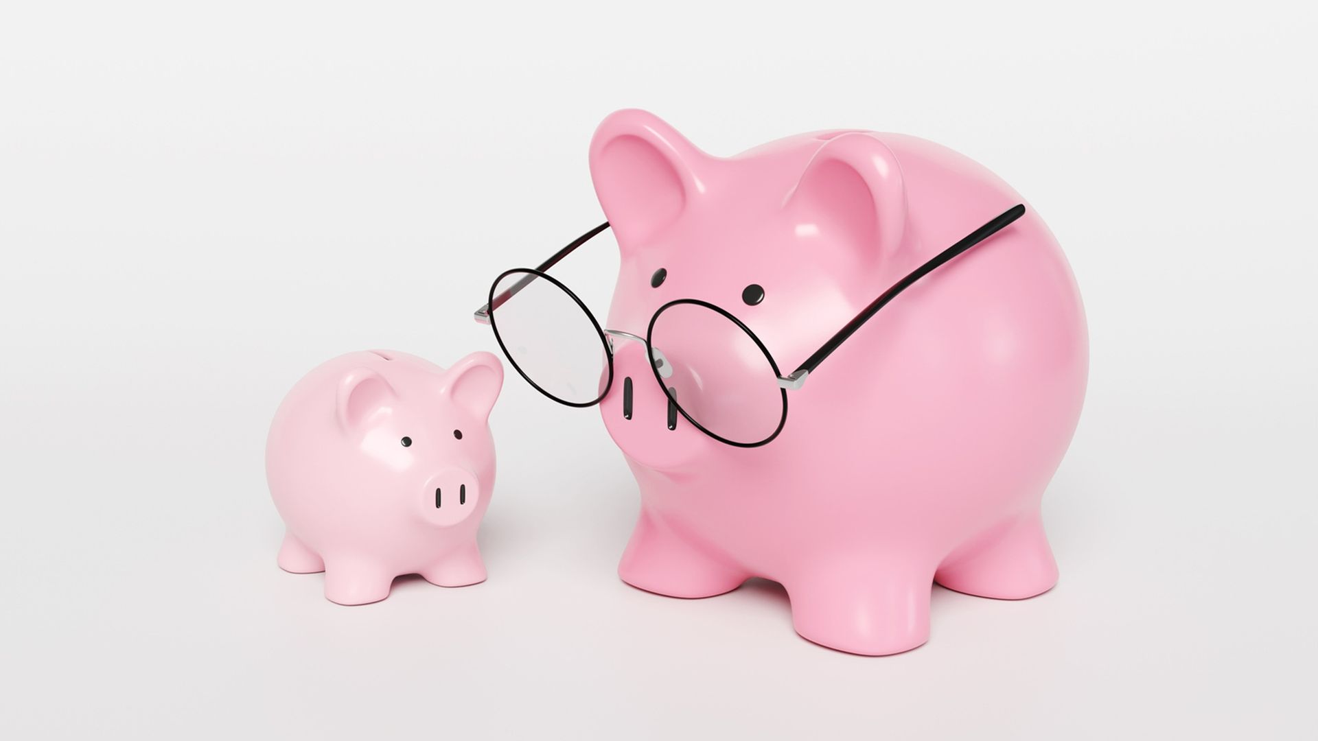 A big pink mother piggy bank wearing spectacles and a smaller piggy bank.