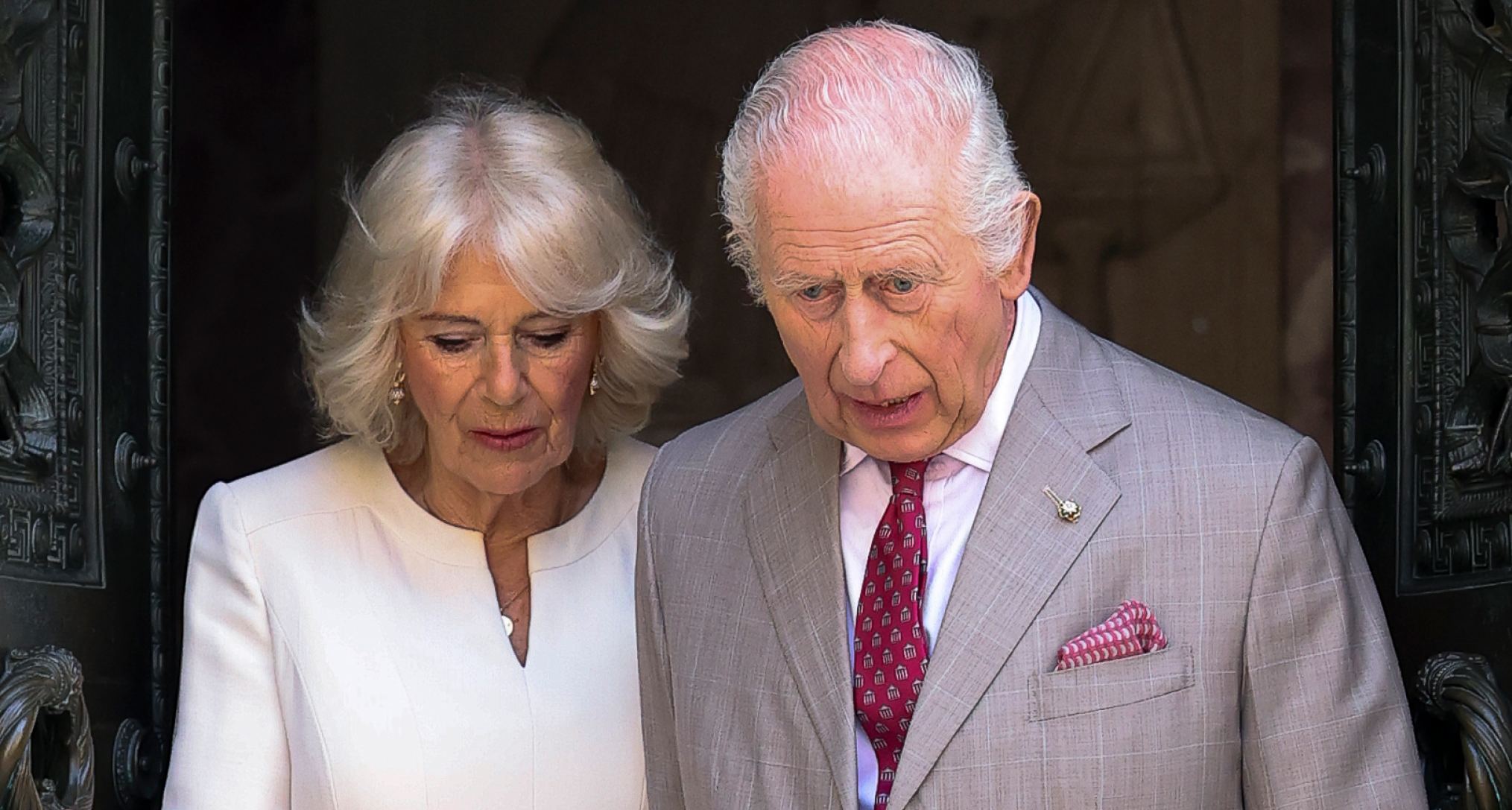 King Charles and Queen Camilla looking downcast