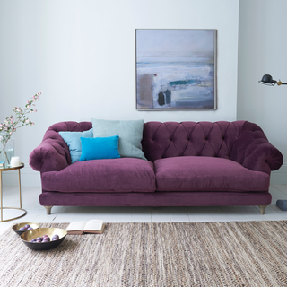 Living room with purple sofa and blue cushions