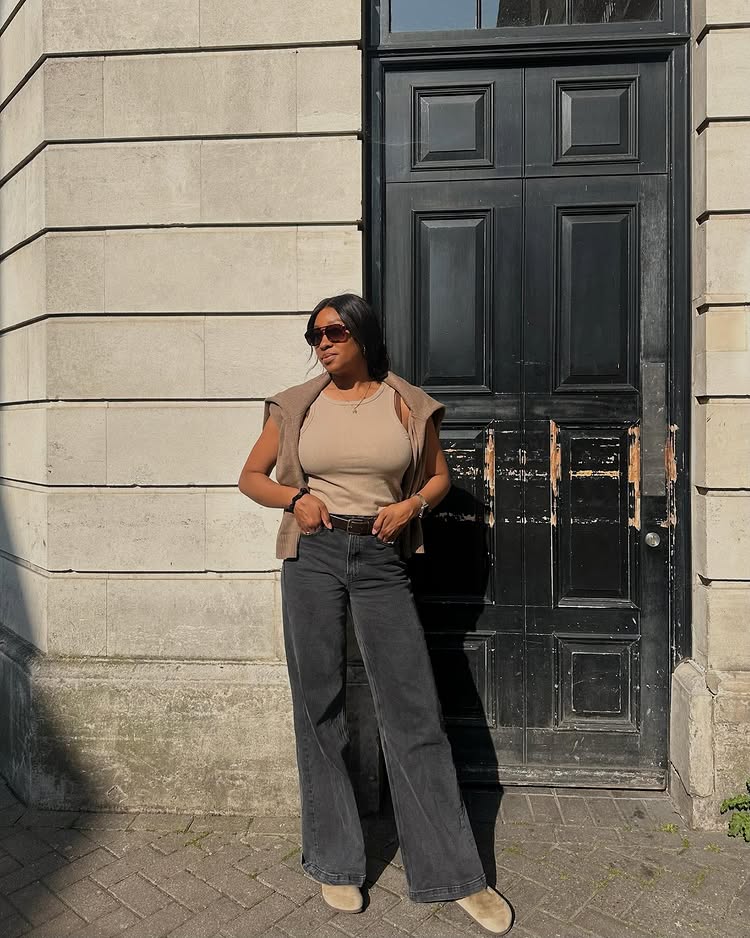 @simplytandya wears a beige vest top, black trousers and suede clog mules