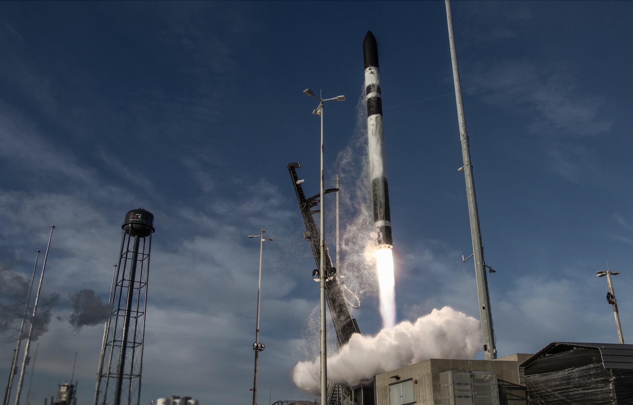 An image of a black and white rocket launching into a blue sky