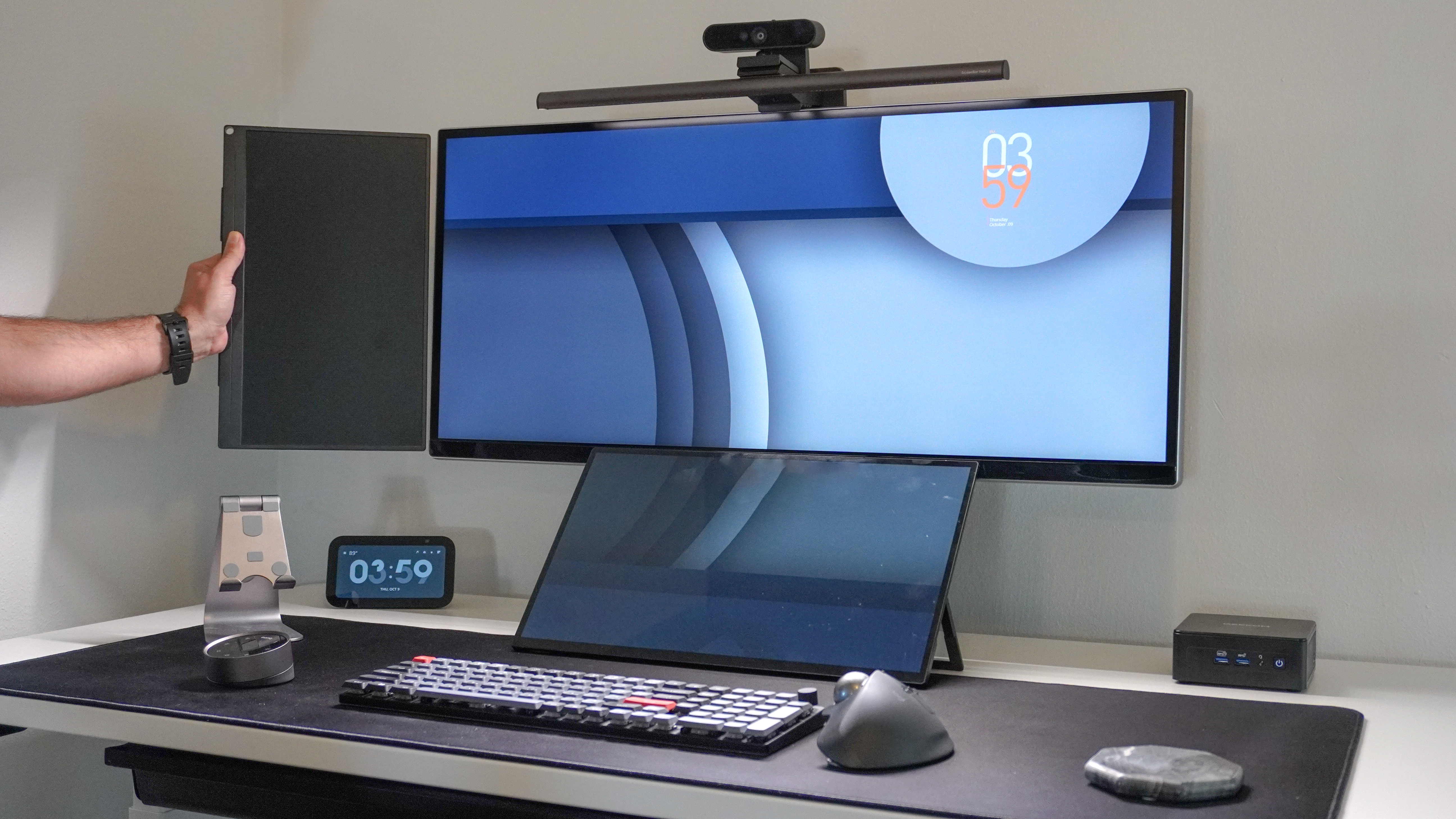 A picture of a person showing how a portable monitor in vertical orientation is the same dimensions as a 34-inch ultrawide display