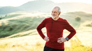 Senior man exercising in rural location wearing a fitness tracker
