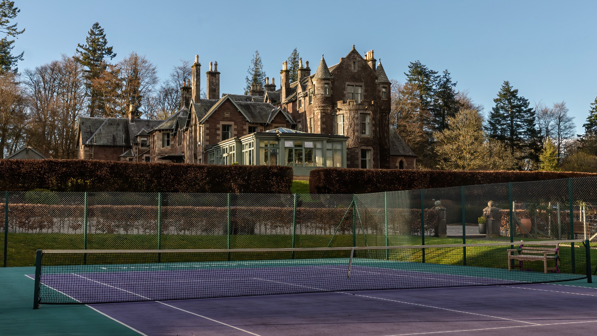 The purple and green tennis court at Cromlix is in the Wimbledon colors