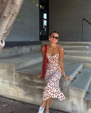 woman wearing cherry printed slip dress and sneakers outfit