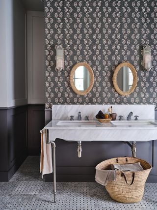 Gray bathroom with wallpaper and a double sink with marble countertop