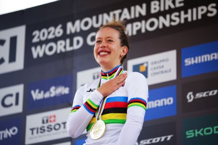 Anja Grossmann smiles on the podium of the 2026 UCI Mountain Bike World Championships, wearing a gold medal and the rainbow jersey