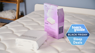 Purple Waterproof Mattress Protector out of the package kept on the bed in TG Sleep Studio with TG Black Friday Sleep Deals badge on the right