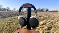 Beyerdynamic Aventho 300 placed on a headphones stand with a field in the background