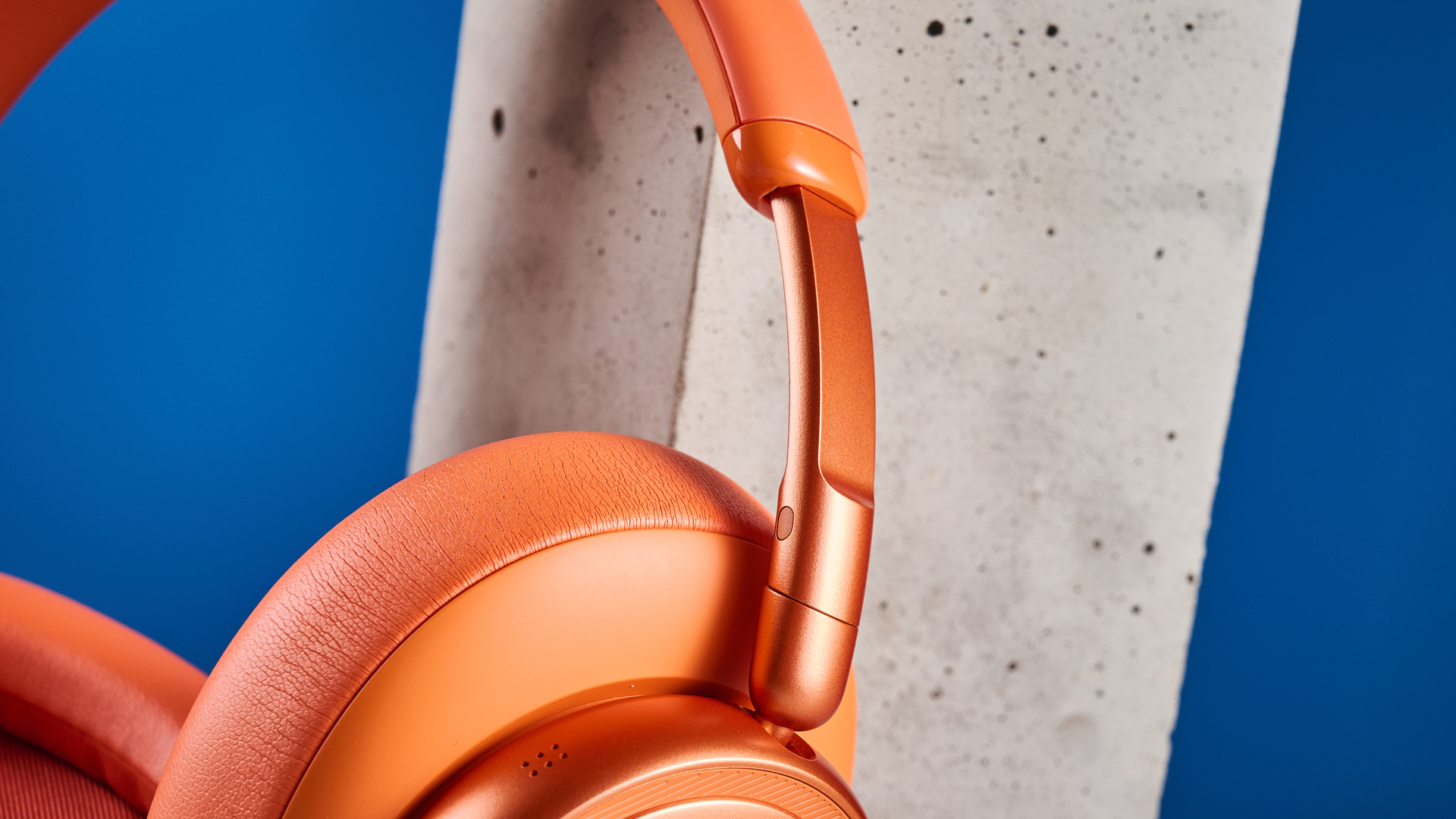 the jbl live 780NC in orange photographed against the blue tom's guide background