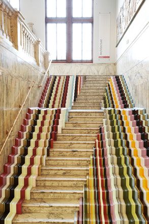 A view of a staircase from the bottom to the top featuring a colourful marble design