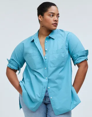 model wears aqua blue poplin cotton button down top with pockets in the front paired with light wash jeans