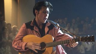 Bästa HBO Max-filmer: Elvis står uppe på scen iklädd en rosa kostym och spelar gitarr och sjunger.