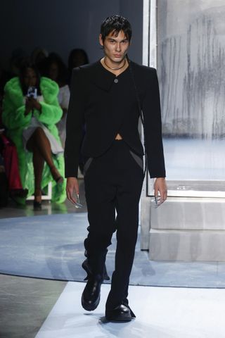 Model walking Head of State runway in black jacket and trousers