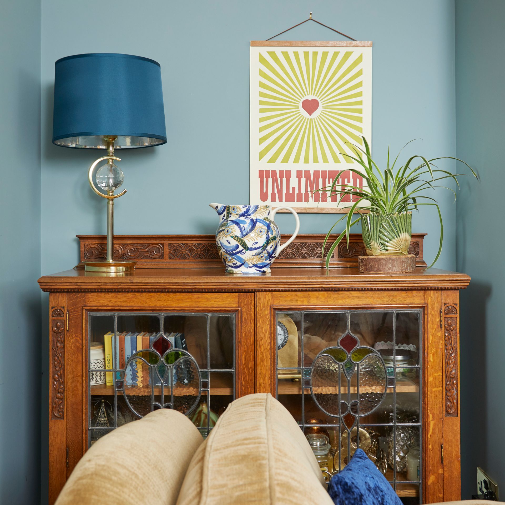 Console table storing books and decorative items with lamp and vase displayed on top