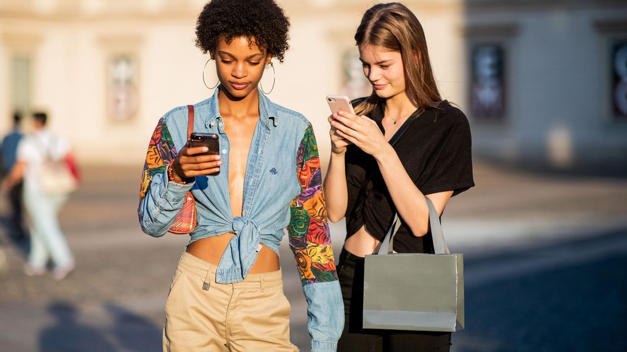 Two women looking down at their mobile phone screens