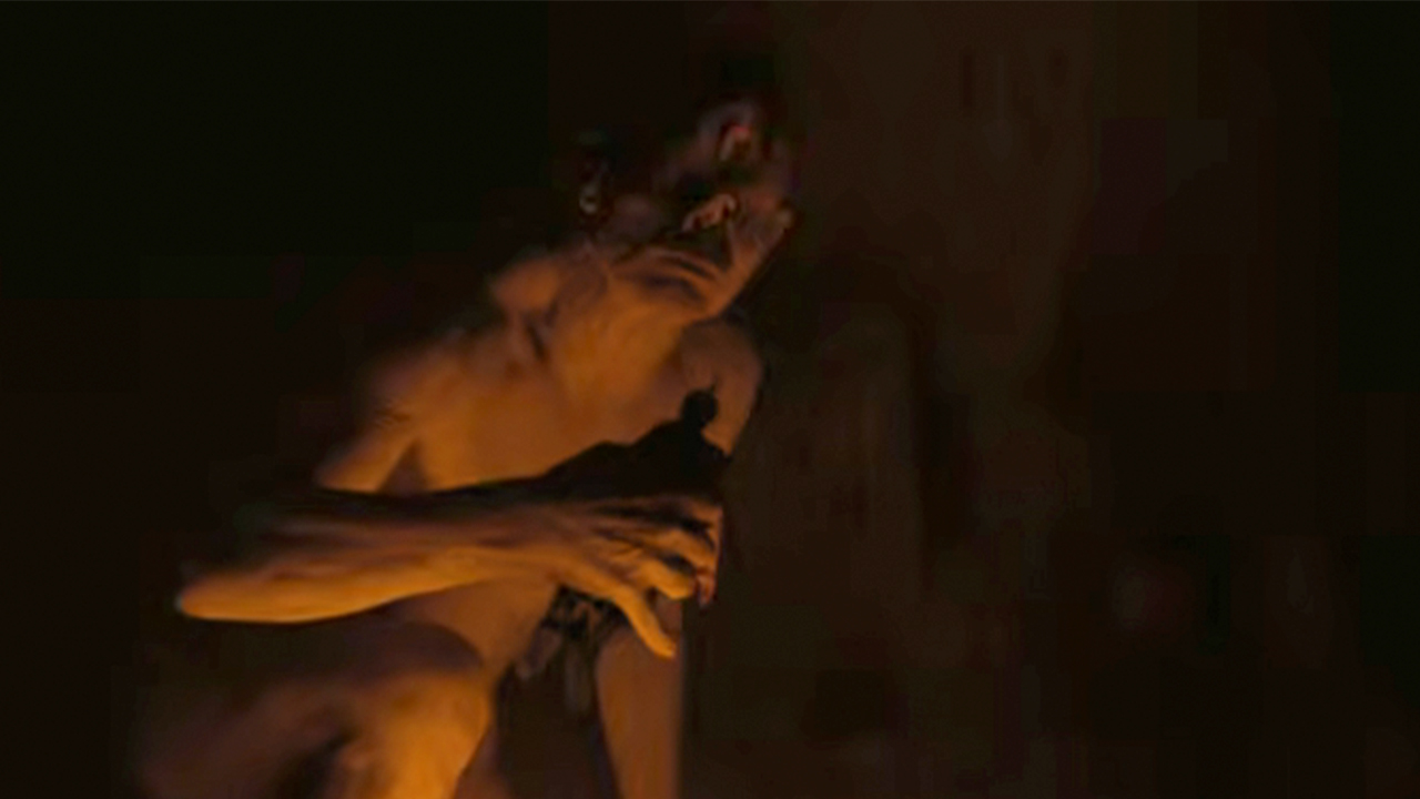 Bill Irwin as the cyclops in The Odyssey, holding one of the Greek soldiers in his hand.