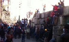 Protesters attack a police barricade, in Cairo.