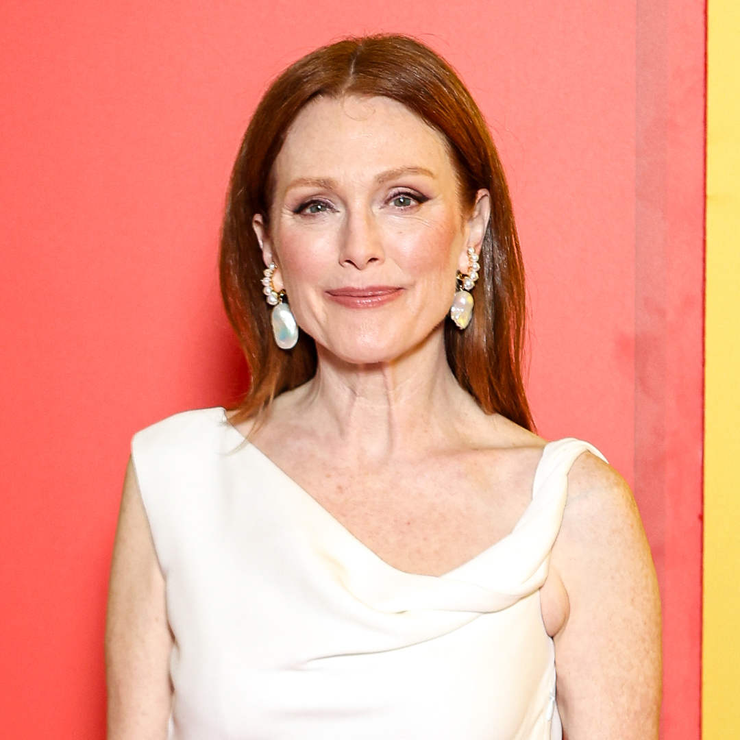 Julianne Moore wearing a white dress and dangly pearl earrings with her red hair styled to fall over her shoulders.
