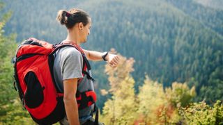 Hiker in forest checking GPS watch