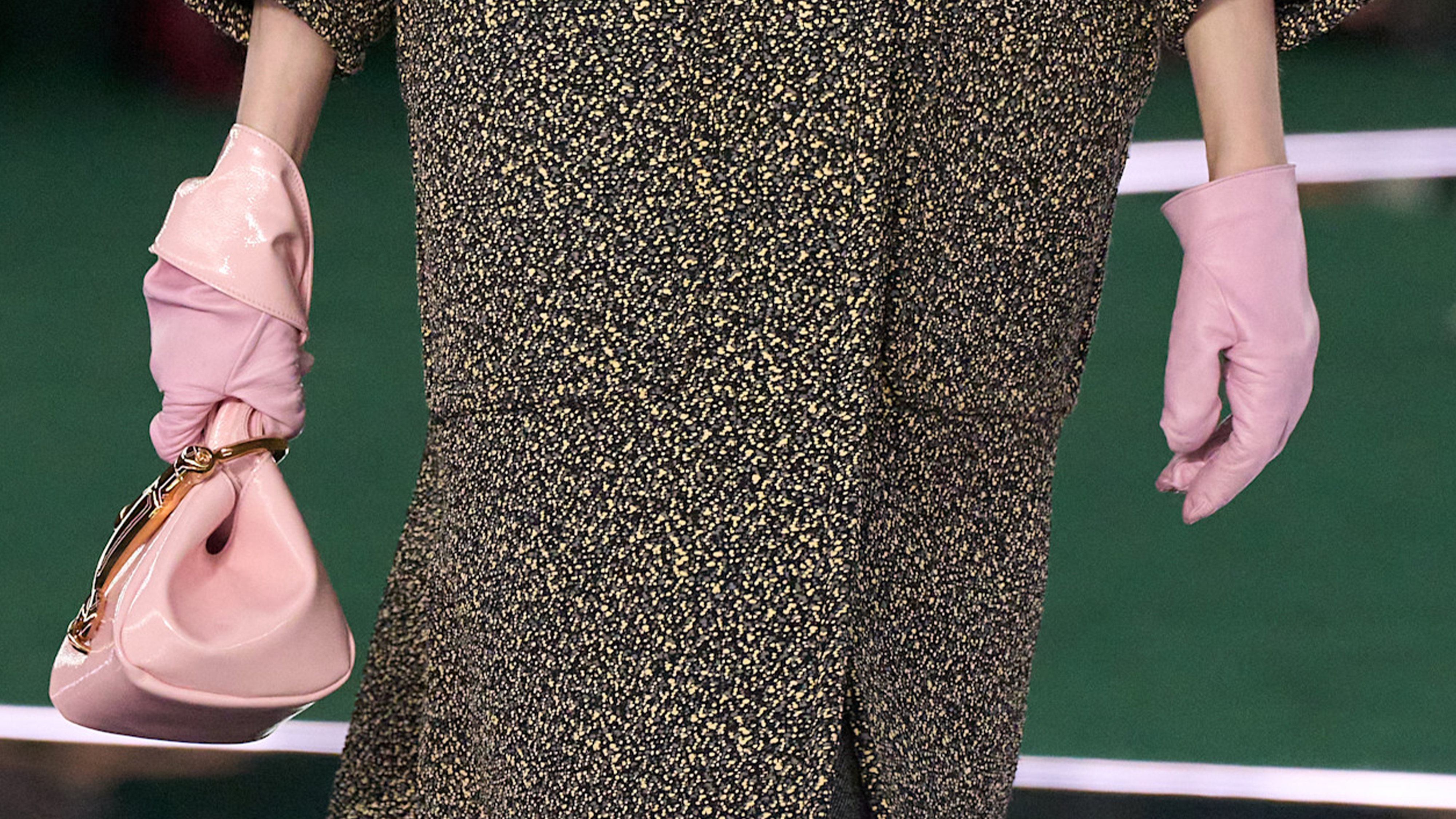 Gucci model wearing light pink leather gloves on the runway.