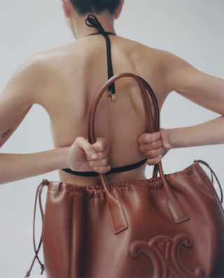 Woman in bikini holding Celine handbag